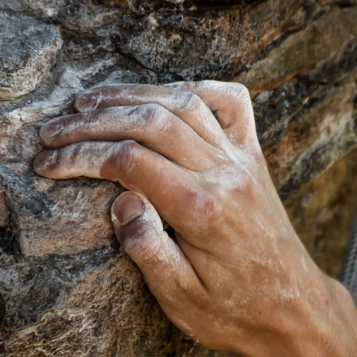 A hand grabbing a crevice while rockclimbing