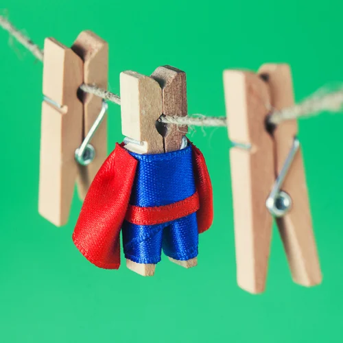 A clothespin on a clothesline dressed like a superhero